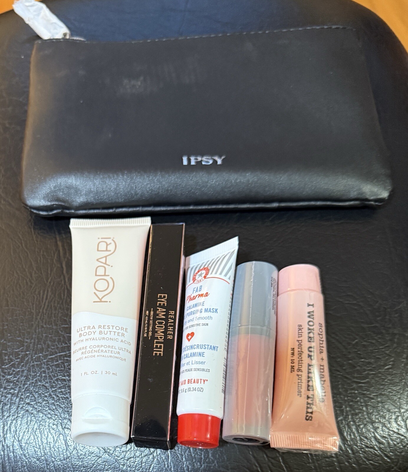 Black Ipsy bag with 5 Sealed sample products